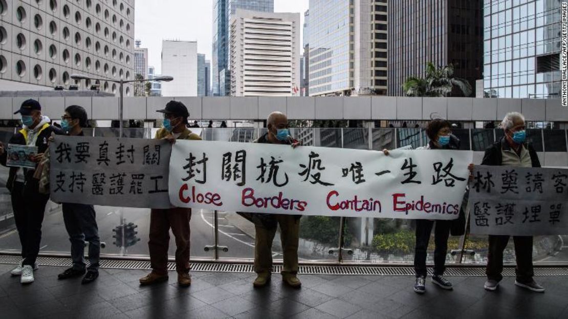 Manifestantes en Hong Kong sostienen una pancarta el 3 de febrero de 2020 para pedir que el gobierno cierre sus fronteras con China continental para reducir la propagación del coronavirus de Wuhan.