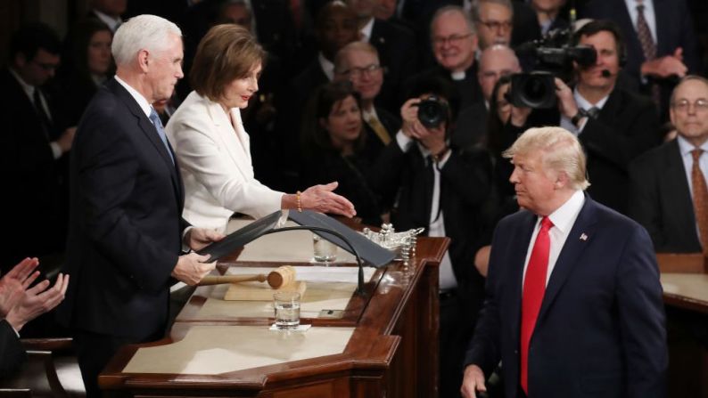 La presidenta de la Cámara de Representantes, Nancy Pelosi, sentada detrás de Donald Trump, se acercó para estrecharle la mano. Trump no se la dio.