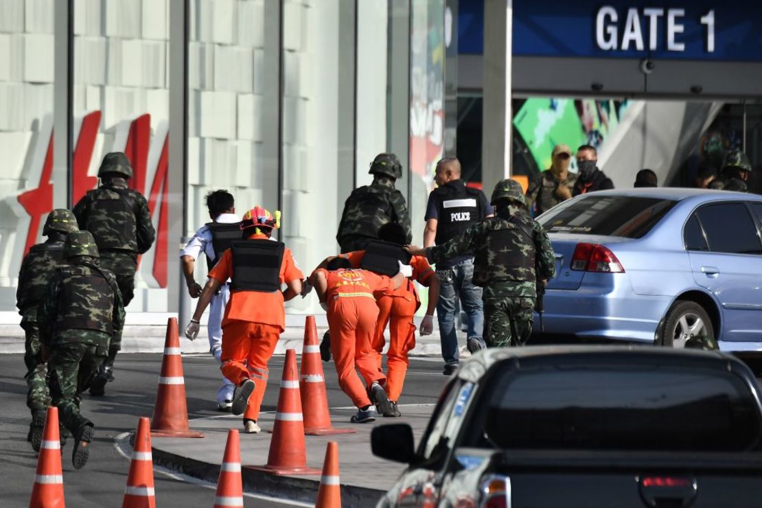 Personal médico (en naranja) se prepara para ingresar al centro comercial Terminal 21, donde se produjo el tiroteo masivo / Crédito: LILLIAN SUWANRUMPHA / AFP a través de Getty Images