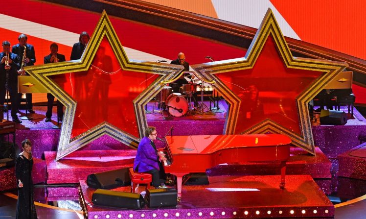 Con un piano magenta y unas gigantescas estrellas –inspiradas en sus famosos y estrambóticos lentes–, Elton John se toma el escenario del Dolby Theatre de Los Ángeles para interpretar “I’m Gonna Love Me Again”, tema nominado al Oscar por mejor canción original.