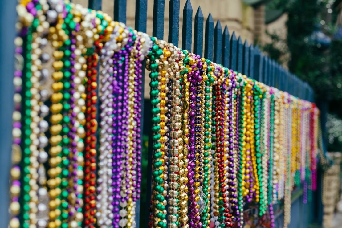 Los tradicionales collares multicolores se lanzan a las personas desde los balcones de los edificios en el barrio Francés o French Quarter. Los colores tradiciones y su significado son tres: morado para la justicia, dorado para el poder y verde para la fe. (Fotografía Paul Broussard. Cortesía New Orleans & Company).