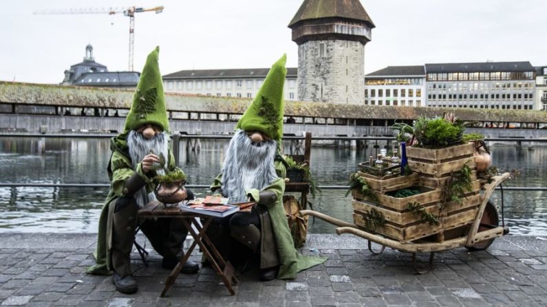 Lucerna, Suiza: Carnavaleros disfrazados posan frente al Puente de la Capilla en el día inaugural del Carnaval el jueves 20 de febrero.