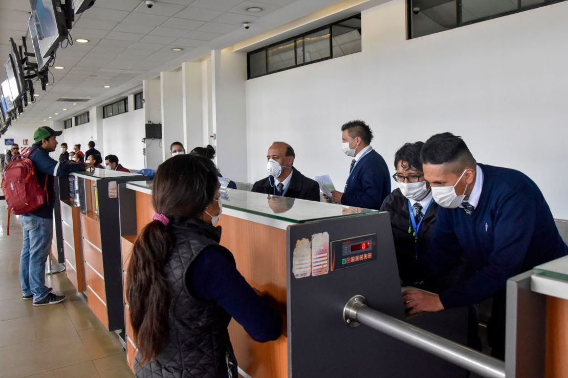 Trabajadores de aerolíneas y pasajeros utilizan máscaras de protección en el Aeropuerto Internacional El Alto en La Paz.