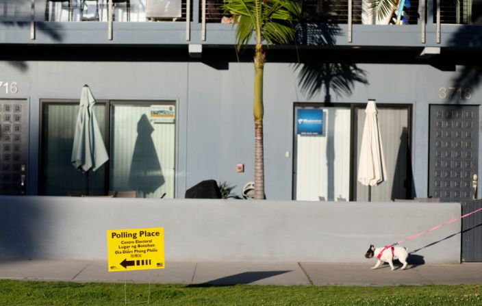 Un perro camina frente a un lugar de votación en San Diego, California.