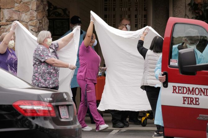 Los trabajadores de la salud transfieren a un paciente en el Centro Life Care en Kirkland, Washington, el domingo 1 de marzo. El centro de cuidados a largo plazo está relacionado con casos confirmados de coronavirus.