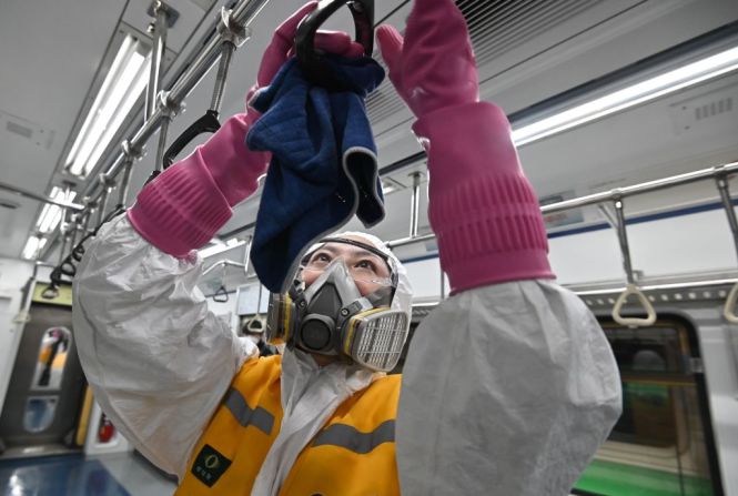 Un trabajador que usa equipo de protección desinfecta un tren para ayudar a prevenir la propagación del coronavirus COVID-19, en el depósito de trenes Metro Gunja de Seúl en Seúl el 11 de marzo de 2020.