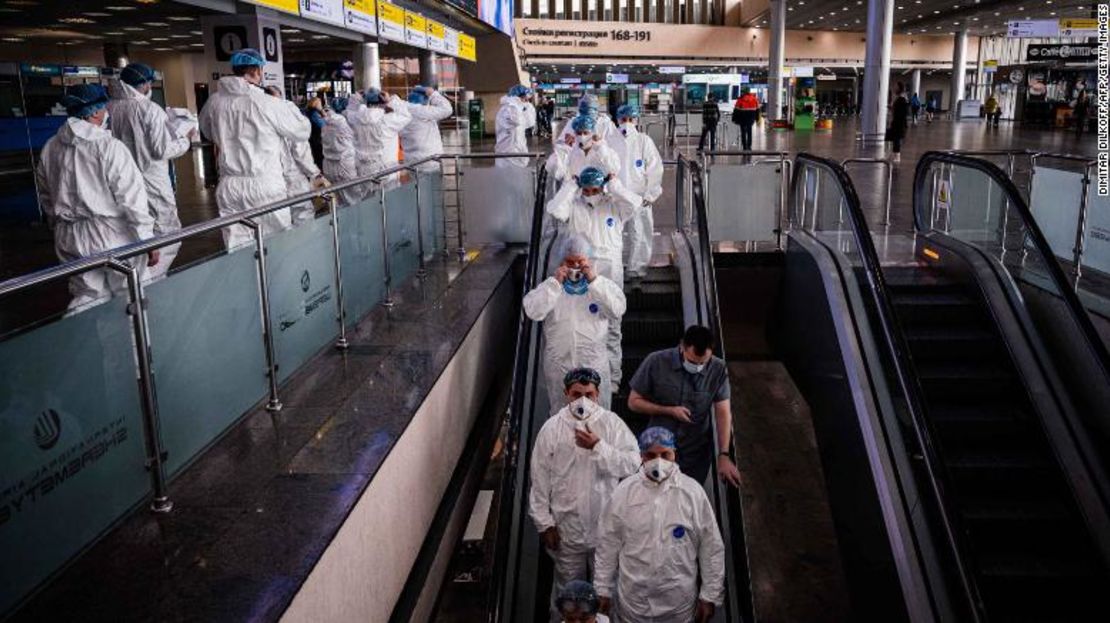 Personal médico con trajes protectores bajaba por una escalera mecánica en el aeropuerto Sheremetyevo de Moscú, el 18 de marzo de 2020.