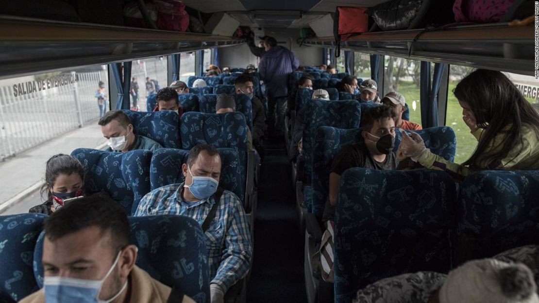 Venezuelan migrants wear protective masks while sitting on a bus that will return them back to Venezuela, in Bogota, Colombia, on Sunday, April 5, 2020. Venezuelan families made destitute by Colombia's coronavirus lockdown are traveling a thousand miles or more across the Andes to get back home. Photographer: Ivan Valencia/Bloomberg