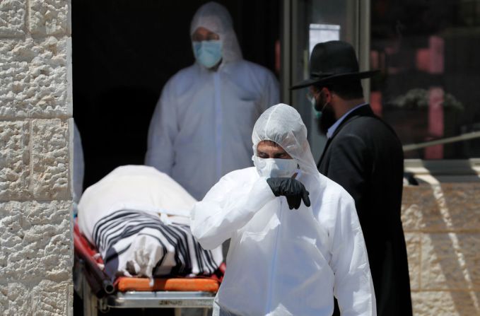 Trabajadores funerarios en Israel preparan el funeral del exrabino principal sefardí de Israel Eliahu Bakshi-Doron, quien murió por complicaciones de la infección por coronavirus la noche anterior, en el cementerio har HaMenuchot en Jerusalén el 13 de abril de 2020.