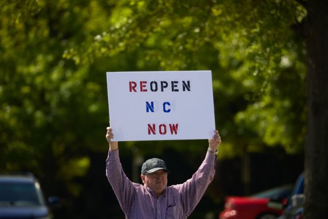 Un manifestante de una organización llamada REOPEN NC protestan contra el confinamiento por coronavirus de Carolina del Norte en un estacionamiento adyacente a la Legislatura del Estado de Carolina del Norte en Raleigh, Carolina del Norte, el 14 de abril de 2020.