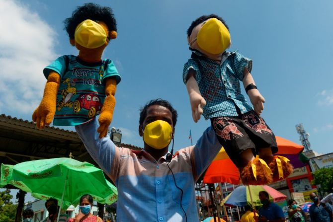 En Chennai, una ciudad en la bahía de Bengala en el este de India, un hombre usa títeres con tapabocas para alertar a los transeúntes de tomar las medidas necesarias para protegerse del coronavirus.