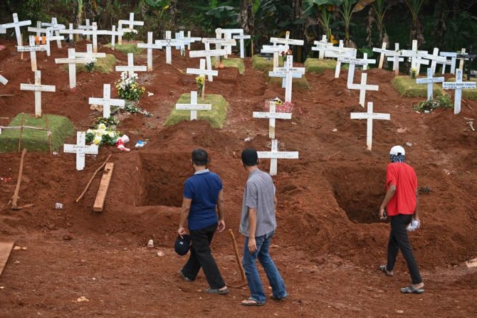 Familiares de víctimas del covid-19 caminan cerca de las tumbas de un cementerio en Jakarta, Indonesia, en el que entierran quienes murieron por esta enfermedad el 15 de abril de 2020. Para ese momento, Indonesia registraba poco más de 5.100 casos de covid-19 y 469 muertos.