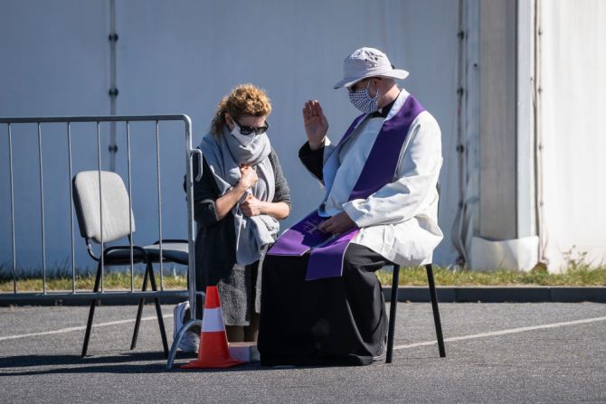 Un sacerdote con un tapabocas, confiesa a una creyente en un estacionamiento frente al Templo de la Divina Providencia en Varsovia, Polonia, en preparación a la Pascua, el 8 de abril de 2020. El coronavirus hizo que la mayoría de países dieran órdenes de confinamiento y prohibieran las reuniones masivas de personas para evitar la propagación del covid-19.