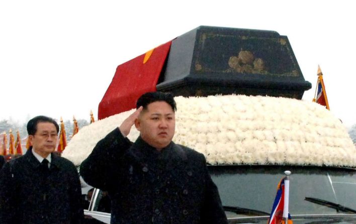 Kim saluda al lado de un coche fúnebre que transportaba el cuerpo de su padre en Pyongyang, Corea del Norte, en diciembre de 2011. Kyodo News / AP