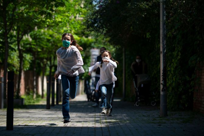 Niños y padres caminan por La Rambla del Poblenou, en Barcelona. Los niños vuelven a las calles en España tras más de 40 días de confinamiento.