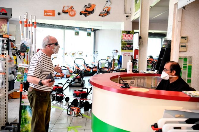 Un hombre usando un tapabocas habla con un empleado de una tienda de jardinería en Amboise, Francia, el 24 de abril, dos días después de que se reabriera tras 39 días de confinamiento. Alrededor del mundo, algunos gobiernos están empezando a relajar lentamente las medidas de distanciamiento social. Mira en esta galería cómo se ve la nueva normalidad.