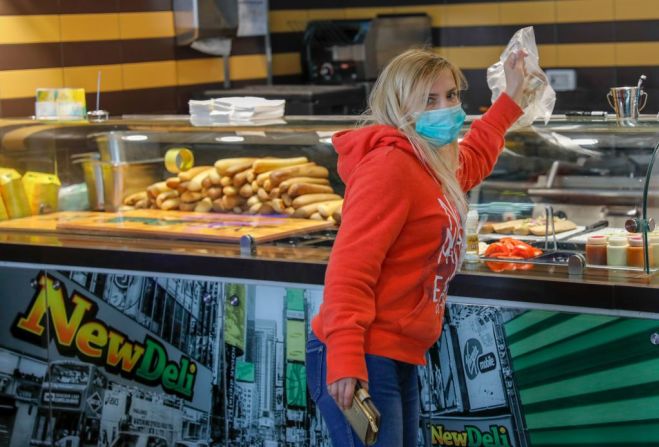 Una mujer en Israel recoge un pedido en un restaurante en Jerusalén después de que el gobierno relajara algunas medidas de confinamiento. Aunque los centros comerciales siguen cerrados, otras tiendas están autorizadas a abrir siempre y cuando sigan estrictas medidas de limitar el número de clientes y que usen tapabocas.