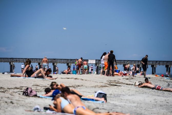 Un grupo de personas se relaja en una playa en Tybee Island, Georgia el 25 de abril. Las playas están empezando a reabrir alrededor del mundo, los estudiantes están regresando a clases y las tiendas están reabriendo por primera vez en semanas. (Photo by CHANDAN KHANNA / AFP).