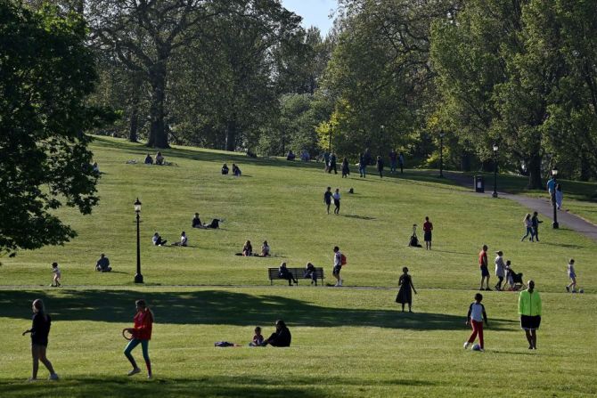 Varias personas se relajan al sol en el parque Primrose Hill en Londres el 25 de abril.