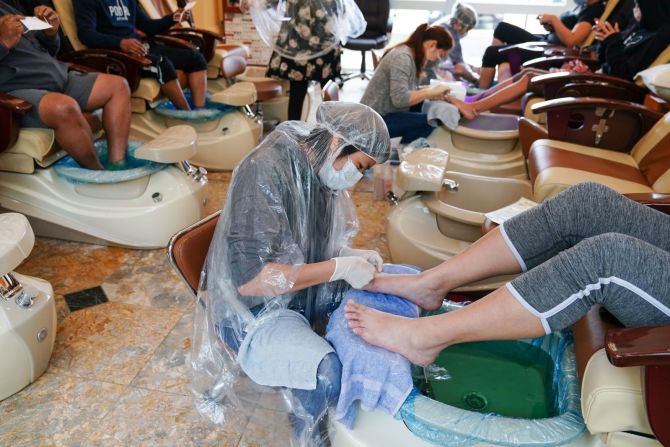 Trabajadores les dan pedicuras a los clientes en un salón de manicura en Atlanta el 24 de abril.