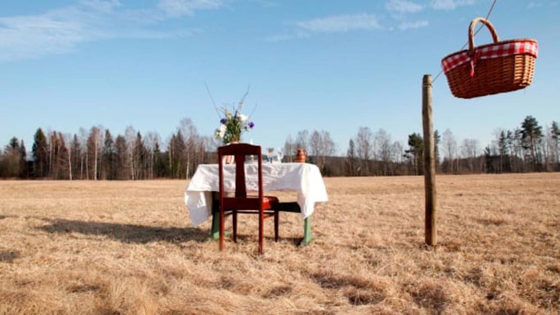 La mesa única del restaurante y la silla están situadas en un exuberante prado en Värmland, Suecia.