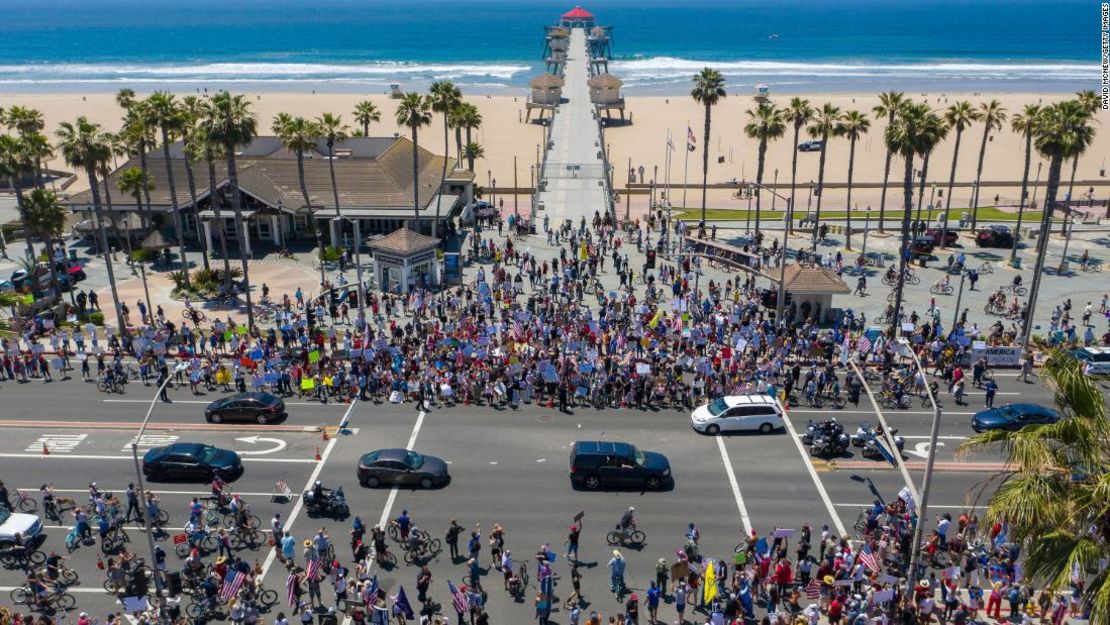 Una vista aérea muestra una multitud de manifestantes llamando a reabrir negocios y playas a medida que la creciente pandemia de coronavirus continúa paralizando la economía en Huntington Beach, California, el 1 de mayo.