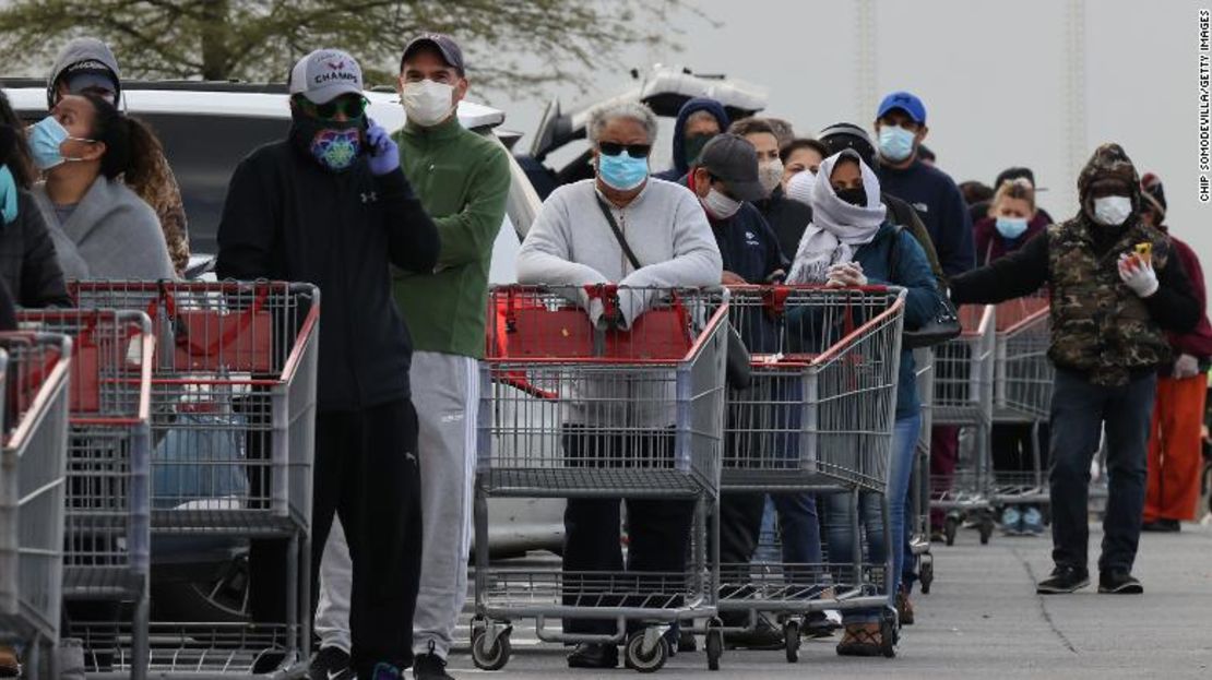 Varios clientes utilizan máscaras faciales mientras esperan afuera de una tienda Costco Wholesale en Maryland.