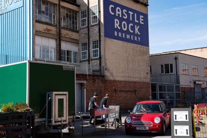 Los miembros del personal de la cervecería Castle Rock en Nottingham, Inglaterra, operan una estación de cerveza drive-thru el 4 de abril. Jacob King / AP