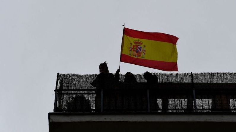 Personas agitan una bandera de España desde su balcón en Madrid durante una protesta contra el gobierno por su gestión de la crisis de coronavirus. GABRIEL BOUYS/AFP via Getty Images