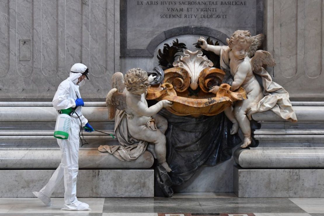 Un hombre viste un mono protector y un aerosol desinfectante con máscara durante el saneamiento de la Basílica de San Pedro en el Vaticano el 15 de mayo de 2020 durante el confinamiento destinado a frenar la propagación de la infección por COVID-19, causada por el nuevo coronavirus.