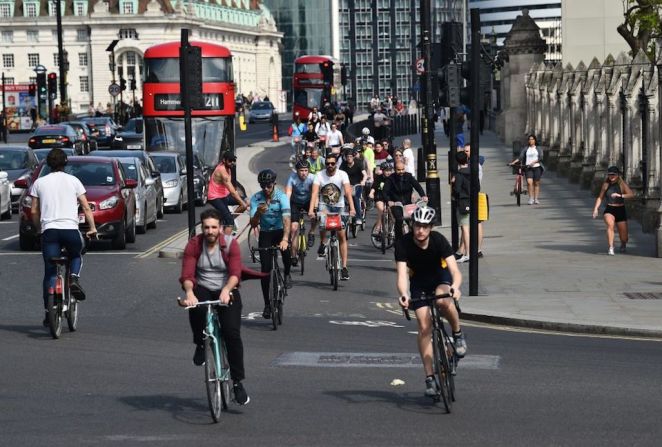 Personas recorre en bicicleta la Plaza del Parlamento en el centro de Londres el 17 de mayo de 2020, luego de una flexibilización de las reglas de confinamiento.