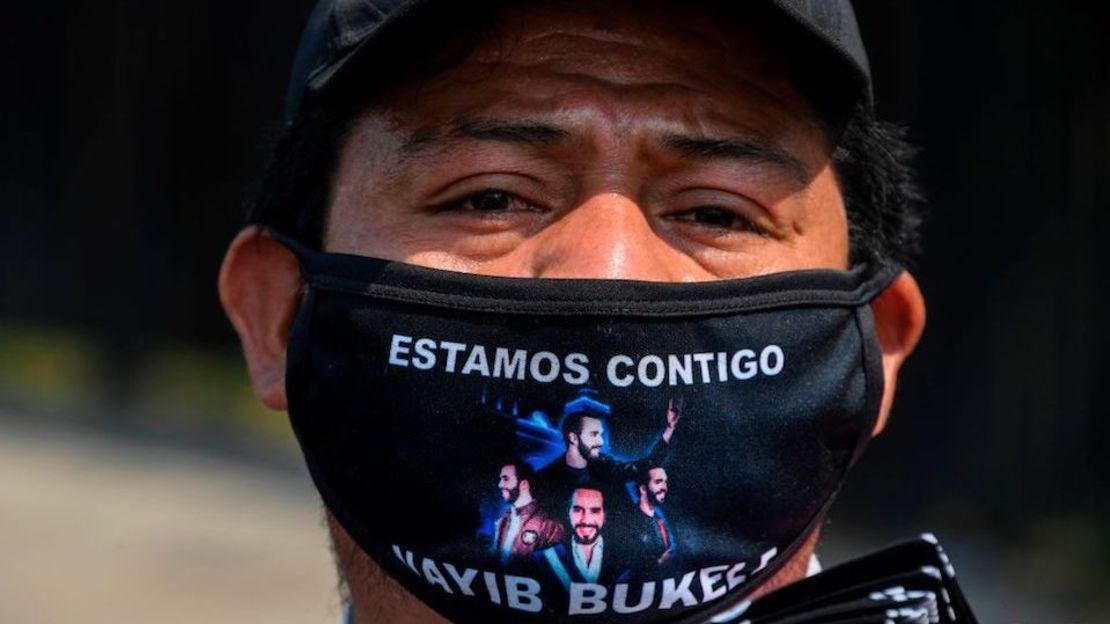 Un vendedor ambulante ofrece máscaras faciales de tela mientras usa una con un mensaje de apoyo para el presidente salvadoreño Nayib Bukele en San Salvador.