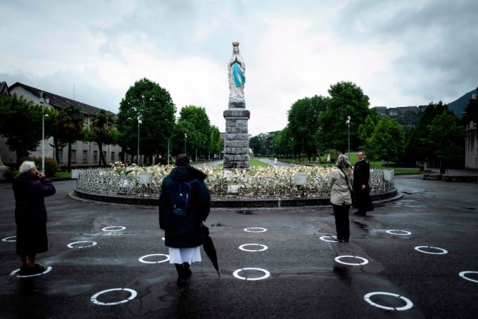 Peregrinos frente a "La vierge couronnée" en el Santuario de Nuestra Señora de Lourdes en el suroeste de Francia.