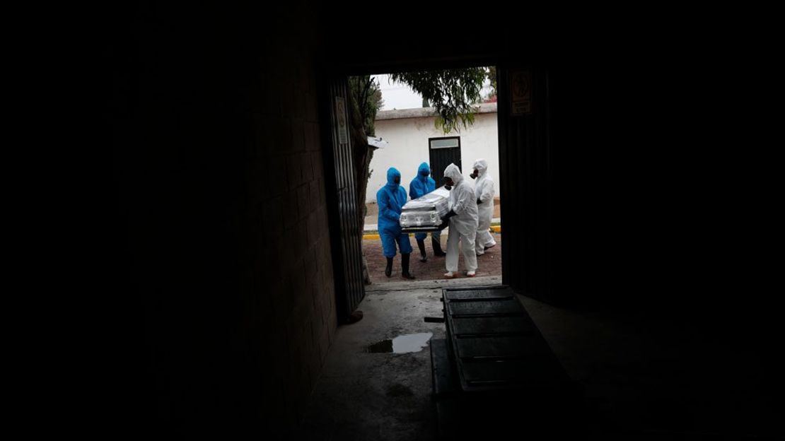 Trabajadores llevan el ataúd envuelto en plástico de un paciente que murió de covid-19 al crematorio en los mausoleos de San Cristóbal en Ecatepec, Estado de México, el jueves. Rebecca Blackwell / AP