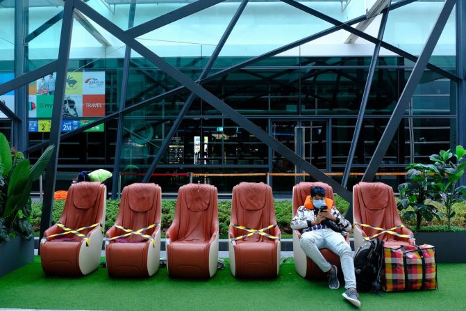 Un viajero se sienta al lado de sillas con marcadores de distancia social en el Aeropuerto Internacional de Kuala Lumpur de Malasia el 13 de mayo. Samsul Said / Bloomberg / Getty Images