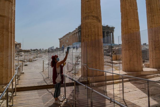 Una mujer limpia un divisor en la entrada de la Acrópolis en Atenas, Grecia, el 18 de mayo. Grecia reabrió todos los sitios arqueológicos al aire libre en el país después de un cierre de dos meses. Aris Messinis / AFP / Getty Images