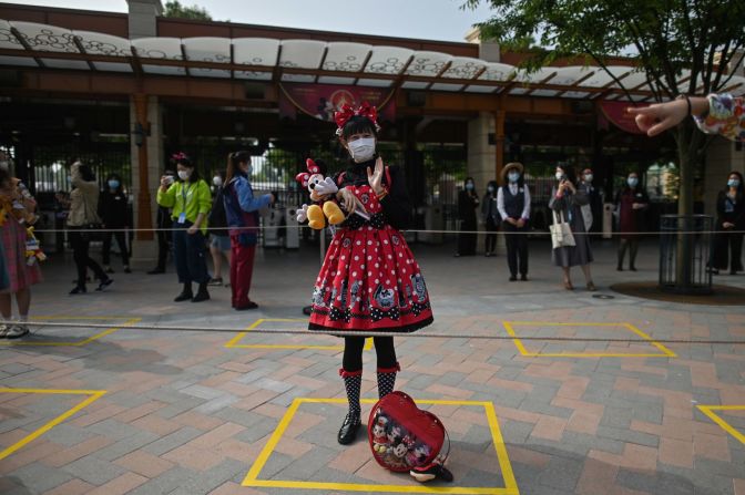 Una mujer permanece en el lugar designado para mantener la distancia mientras esperaba ingresar al parque de atracciones Disneyland en Shanghai, China, el 11 de mayo. El parque había estado cerrado durante tres meses y medio. Los visitantes ahora deben usar máscaras, tomarse la temperatura y practicar el distanciamiento social. Hector Retamal / AFP / Getty Images