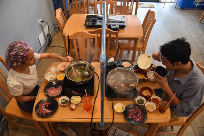 Los clientes almuerzan en Yujin Shabu, un restaurante japonés en Bangkok, Tailandia, el 5 de mayo. El gobierno tailandés ha permitido que algunas empresas reabran con medidas de protección vigentes. Yuttachai Kongprasert / SOPA Images / LightRocke / Getty Images