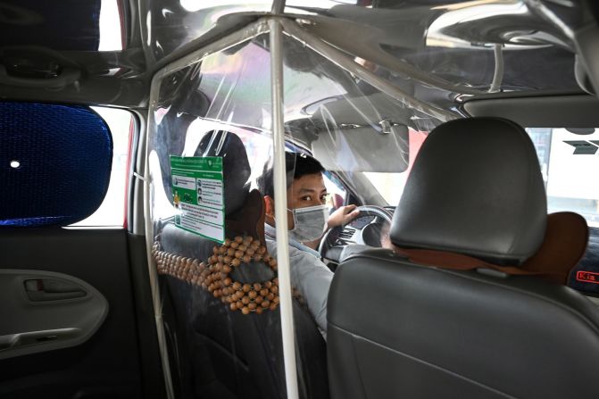 Un taxista en Hanoi, Vietnam, tiene una sábana de plástico a su alrededor. Fotografiado el 19 de mayo. Manan Vatsyayana / AFP / Getty Images