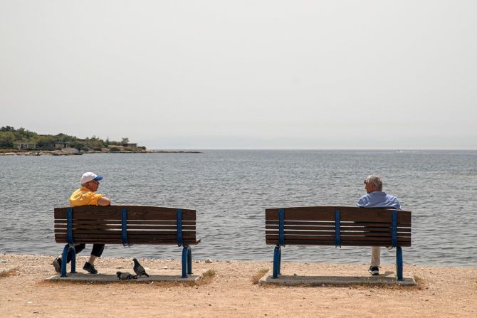 Dos hombres se mantienen alejados mientras hablan en Glyfada, Grecia, el 15 de mayo. Petros Giannakouris / AP