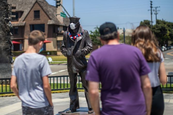 Una familia observa la estatua del Marinero Solitario que lleva una máscara como parte del esfuerzo para recordarles a las personas que deben usar un tapabocas para protegerse contra el coronavirus. Multitudes llenaron playas en Florida, Maryland, Georgia, Virginia e Indiana durante el fin de semana, muchos se aventuraron sin máscaras y otros no pudieron mantener su distancia, incluso cuando los funcionarios han resaltado incansablemente la importancia de ambas para evitar otra oleada de casos. Mira algunas postales del fin de semana en esta galería.