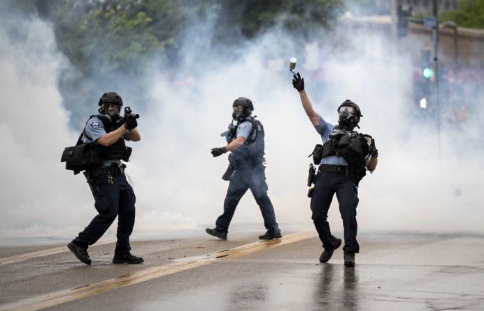 Un policía arroja un bote de gas lacrimógeno hacia los manifestantes durante la protesta. Carlos González / AP