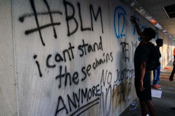 Un hombre pinta con spray una pared del CNN Center en Atlanta durante las protestas por la muerte de George Floyd en la ciudad el 29 de mayo de 2020 (Elijah Nouvelage/Getty Images).