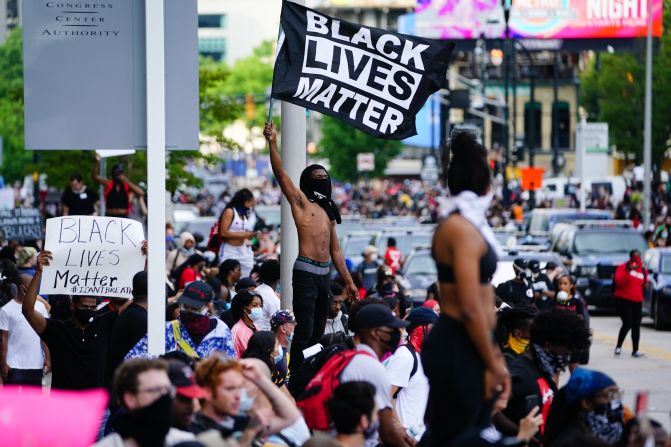 "Las vidas negras importan" es la consigna de la bandera que agita un hombre durante una manifestación en Atlanta este viernes por la muerte de George Floyd, un guardia de seguridad negro que murió luego de que un grupo de policías se arrodillara sobre su cuerpo hasta que no pudo respirar más días atrás en Minneapolis, Minnesota (Elijah Nouvelage/Getty Images).