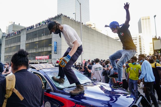 Un manifestante aplasta el vidrio de un auto frente al CNN Center en Atlanta este viernes, durante una manifestación por la muerte de George Floyd (Elijah Nouvelage/Getty Images).