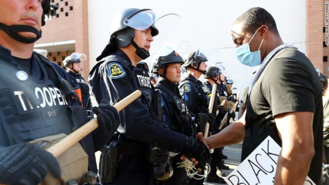 Un manifestante y un policía se dan la mano en Kansas City, Missouri.