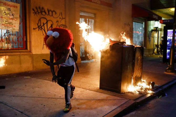 Un manifestante con una máscara de Elmo baila mientras arde un fuego en Filadelfia el 30 de mayo. Matt Rourke / AP