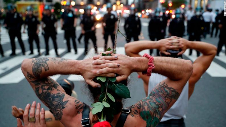 Un grupo de manifestantes se arrodillan frente a policías del Departamento de Policía de Nueva York antes de ser arrestados por violar el toque de queda este miércoles 3 de junio.