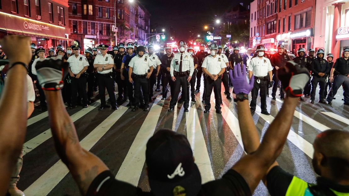 Protesters take a knee on Flatbush Avenue in front of New York City police officers during a solidarity rally for George Floyd, Thursday, June 4, 2020, in the Brooklyn borough of New York. Floyd died after being restrained by Minneapolis police officers on May 25.