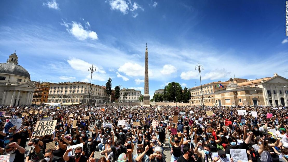 Personas se arrodillan sosteniendo pancartas en Roma.